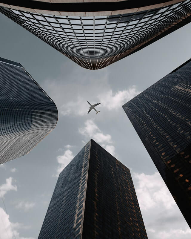In this example, we switch to the vertical tilt mode and apply it to a JPG image of an airplane flying over city skyscrapers. We use a negative tilt angle, which tilts the JPG downward. We use the "ghostwhite" color to fill the newly formed background corners. (Source: Pexels.)