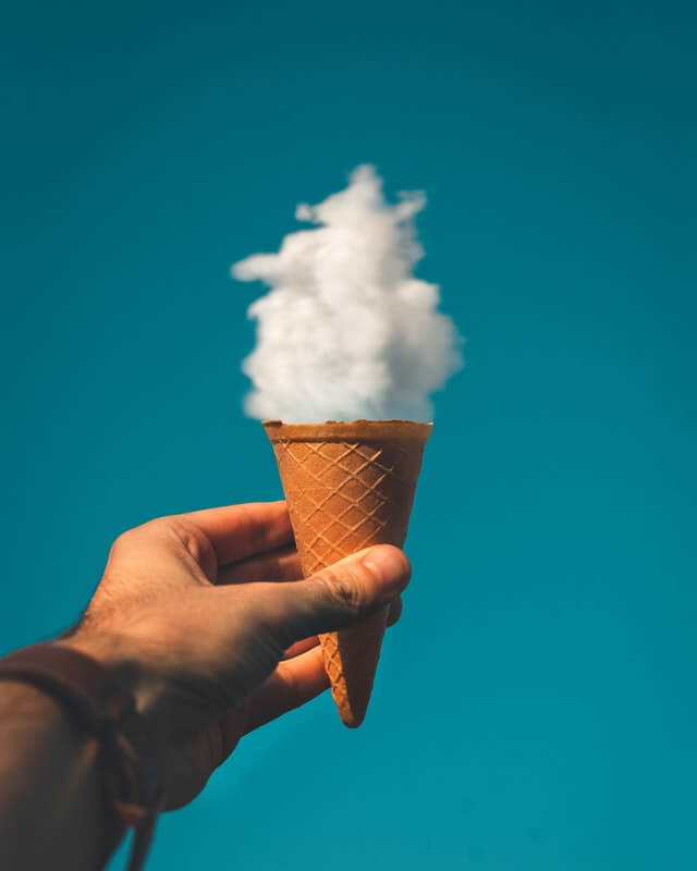 In this example, we remove the turquoise color background from a JPG image of a man holding an ice-cream cone under a cloud. We specify the background color using the hex code "#017284" (which is turquoise) and also remove 14% of similar color tones. (Source: Pexels.)