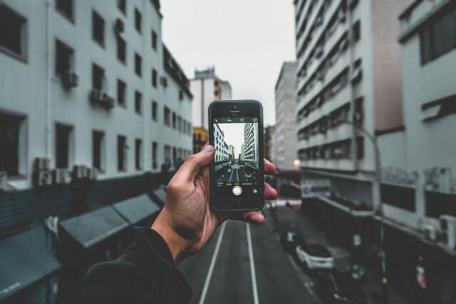 In this example, we apply a sharpening filter to the right half of a JPG photo. We set the strength of the filter to 150%, which makes the part of the phone and city on the photo gain pixel clarity and crispness. (Source: Pexels.)